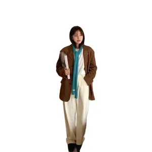 Brown oversized blazer with a blue knitted scarf and white trousers outfit set