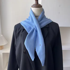 Pañuelo triangular de punto azul claro en maniquí con chaqueta de traje negra chic