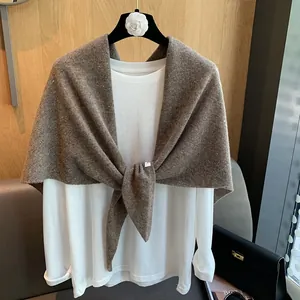 Detail of burgundy wool knit shawl tied over a white long-sleeve tee on a hanger