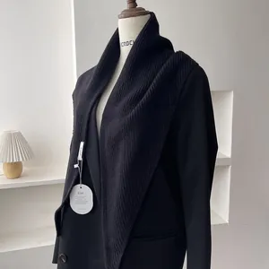 Classic black ribbed knit shawl scarf styled over a suit jacket for early autumn fashion