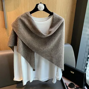Detail showing elegant brown 100% wool knit shawl draped over a white long sleeve shirt