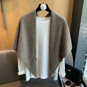 Close-up of brown wool knit shawl texture and thick soft fabric on white shirt