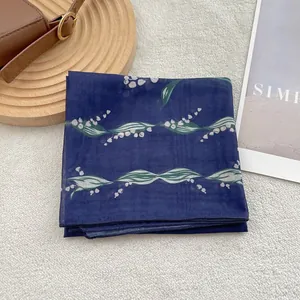 Detailed macro view of lightweight cotton-linen scarf with white lily of valley prints