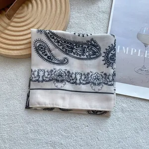 Detail of beige paisley silk scarf with vintage floral patterns on soft background