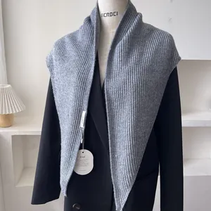 Macro shot of grey ribbed knit shawl texture with brand tags on a black blazer