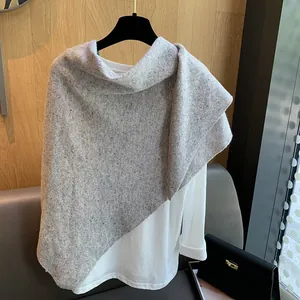 Detail of light grey flecked wool knit shawl with soft texture and natural drape