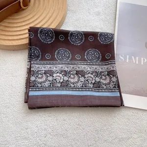 Detail of vintage paisley silk scarf with ethnic totem and floral patterns on soft rug