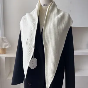 Detailed ribbed texture of a cream knitted shawl styled on a black blazer mannequin