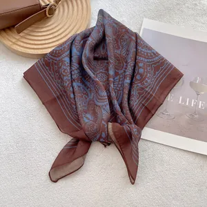 Detail of the vintage mandala print on brown square scarf with neat rolled hem edges