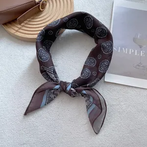 Close-up of vintage brown paisley silk scarf with glossy texture and intricate pattern