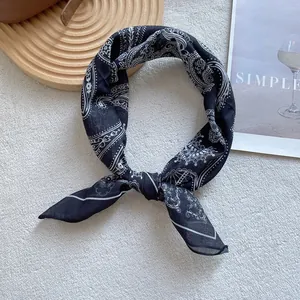 Detail of black and white paisley silk scarf showing soft texture and premium contrast edges