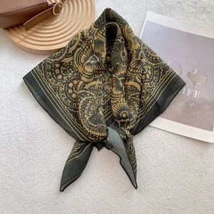 Detail of vintage floral print cotton square scarf on white rug with a brown bag