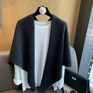 Detail of a dark gray 100% wool knit shawl paired with a classic white long sleeve shirt