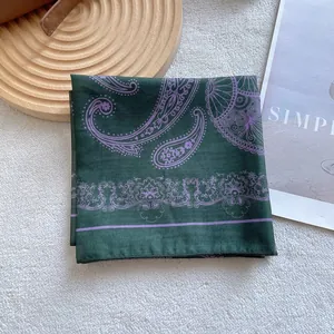 Detail of dark green square silk scarf with purple paisley patterns and vintage borders