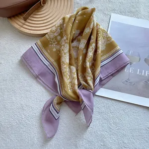 Detail of paisley print silk scarf with yellow and purple floral patterns on velvet