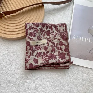Detail of vintage floral silk scarf featuring beige fabric and explore infinity label