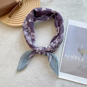 Close-up of a knotted paisley silk scarf with purple patterns on a textured background