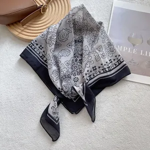 Flat lay of vintage paisley square scarf with heart patterns and black border design