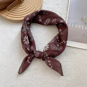 Close-up of silk paisley square scarf in dark chocolate brown with an elegant knot