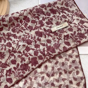Close-up of vintage floral silk scarf texture with explore infinity embroidered tag