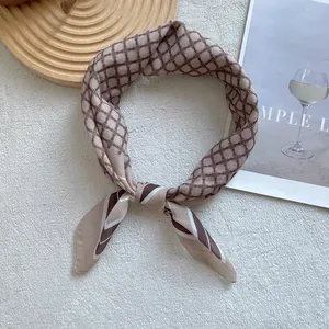 Nahaufnahme eines beigen Seiden-Halstuchs mit Vintage-Geometrie-Muster und Streifendetails
