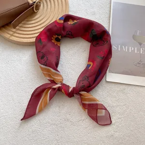 Detail of vintage burgundy square scarf featuring cartoon bears and floral patterns