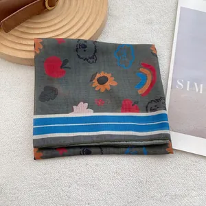 Detailed macro view of thin gray silk scarf featuring cute cartoon apple and koala prints