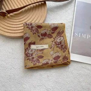 Detail of vintage floral ginger yellow scarf with explore infinity label on soft fabric