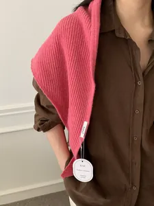 Detailed knit texture of a bright pink ribbed shawl styled over a dark shirt