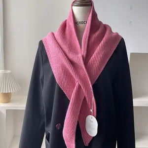 Detail of pink ribbed knit shawl styled over a black blazer on a mannequin display