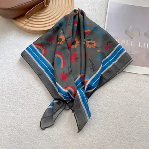Detail of silk-like square scarf with sunflower prints and blue striped edges