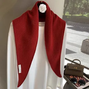 Detail of red knit wool shawl showing fine texture and 8% cashmere wool blend label