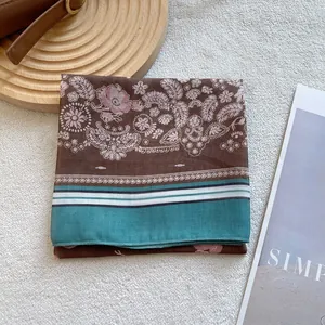 Detail of floral paisley silk scarf with geometric border and fine stitched edges