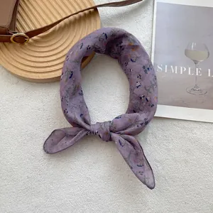 Detail of purple floral silk scarf showing soft chiffon texture and elegant drape knot