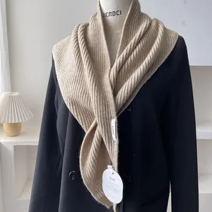 Close-up of beige ribbed knit shawl material texture on a black blazer with brand labels