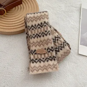 Close-up van Fair Isle gebreide sjaal met beige patroon en bruine lederen patch
