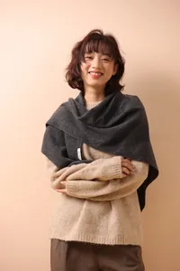 Detail shot of 100% wool material tag on dark grey knit shawl scarf for women