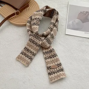 Detailopname van Fair Isle gebreide sjaal met lederen merkpatch en warme patronen