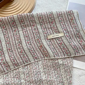 Detail of floral cotton linen headscarf with small flower patterns and explore tag