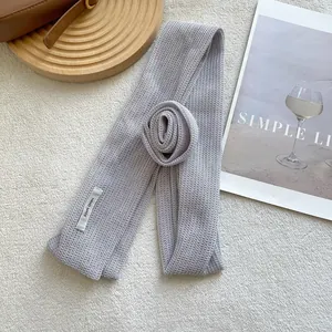 Macro view of light grey knit floral silk scarf with textured honeycomb hand-made weave