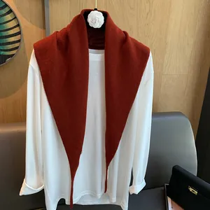 Dunkelroter Strickschal aus Wolle in Dreiecksform über einem weißen Langarmshirt
