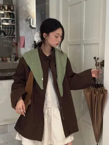Detail eines grünen Strickschals aus Wolle über einer braunen Jacke für den Herbst