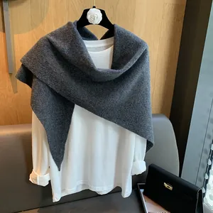 Deep gray hollow knit triangular shawl scarf paired with a white long-sleeve base top