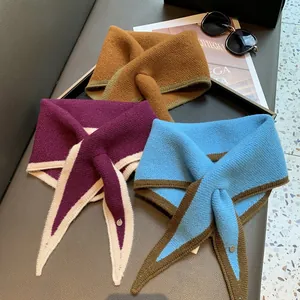 Detailed close-up of knitted triangular scarves with crossover loops in various colorways