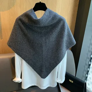 Detail view of thick grey knitted hollow shawl cape texture over white base layer