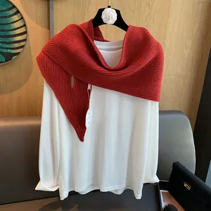 Detail eines roten vertikal gestreiften Strickschals kombiniert mit weißem Baumwoll-T-Shirt