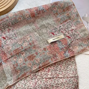 Detail of floral cotton linen headscarf with explore infinity label on wood plate