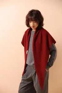Detailed view of red hollow knit triangle scarf with delicate texture and soft drape