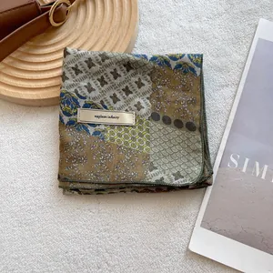 Detailed fabric texture of floral cotton linen scarf with Explore Infinity label