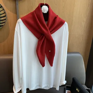 Elegant 100% wool red knit scarf with white camellia flower on a white long-sleeve shirt